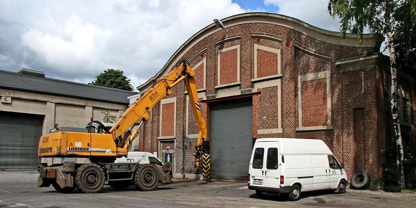 Kesselhaus 3 Außenansicht, rotes Backsteingebäude, davor ein weißer Sprinter und ein gelber Baggerlader