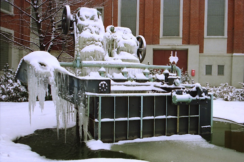 Kaskaden-Wasserspiel im Winter, vereist und mit Schnee bedeckt