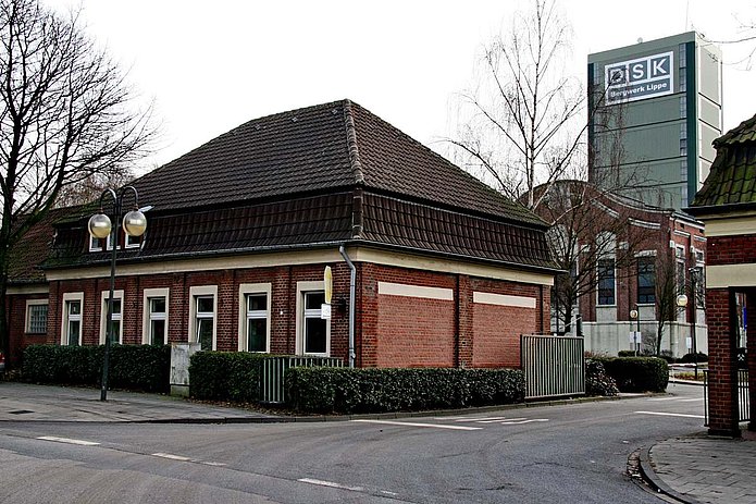 Torhaus Ost Außenansicht, rotes Backsteinhaus mit Hecke umzäunt