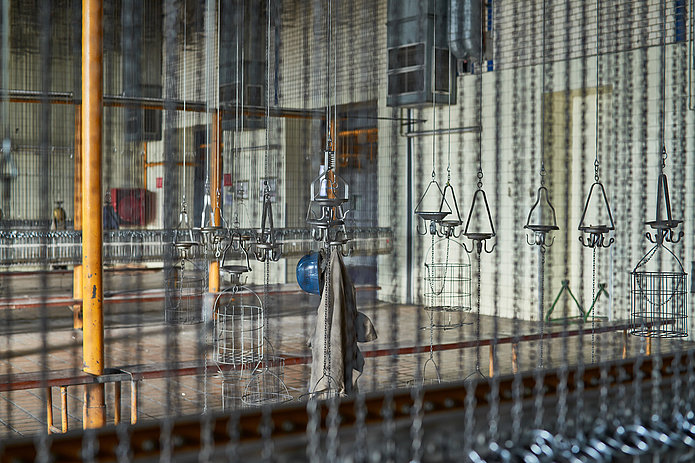 In der Kaue hängt an einem zentralen Kauenkorb ein blauer Helm und vermutlich eine alte Arbeitsjacke.