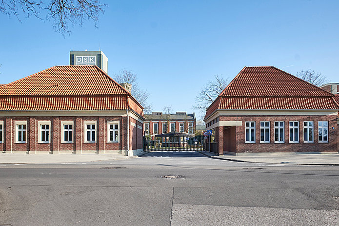 Die beiden Torhäuser bilden den Eingang zum Gelände der Zeche Westerholt. Dazwischen verläuft eine Straße, die durch ein Tor zwischen den Häusern führt.