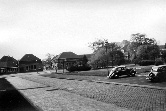 Torhaus Ost und West Außenansicht, ein davor liegender Parkplatz mit zwei parkenden Autos, historische schwarz-weiß Aufnahme 