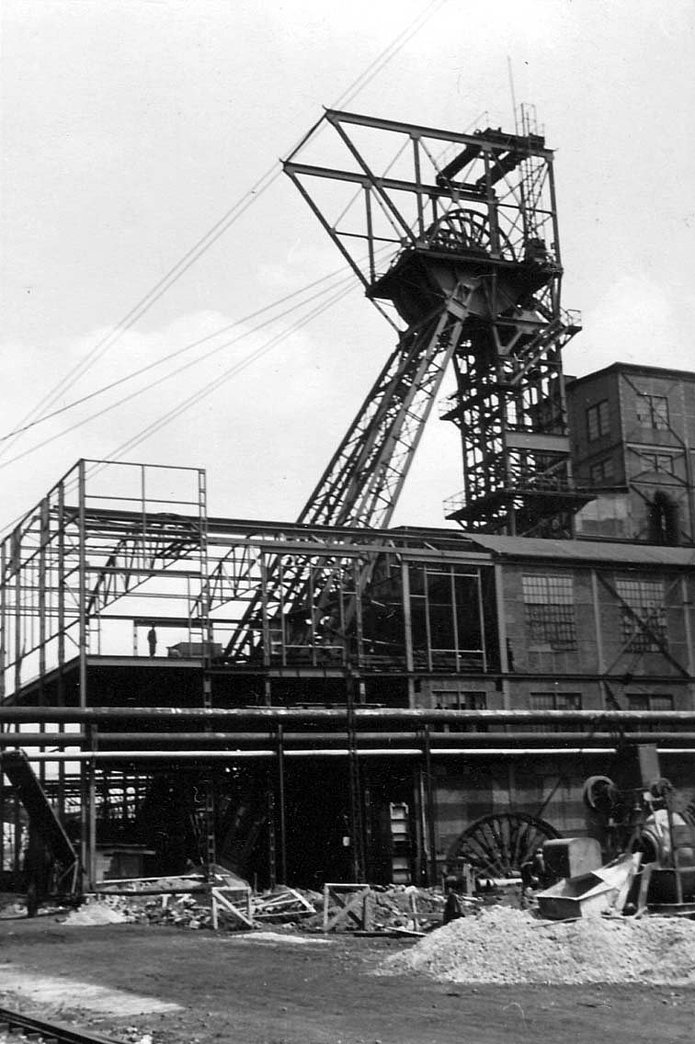 Schacht 1 Außenansicht, Baustelle mit Gerüst am Gebäude, historische schwarz-weiß Aufnahme 